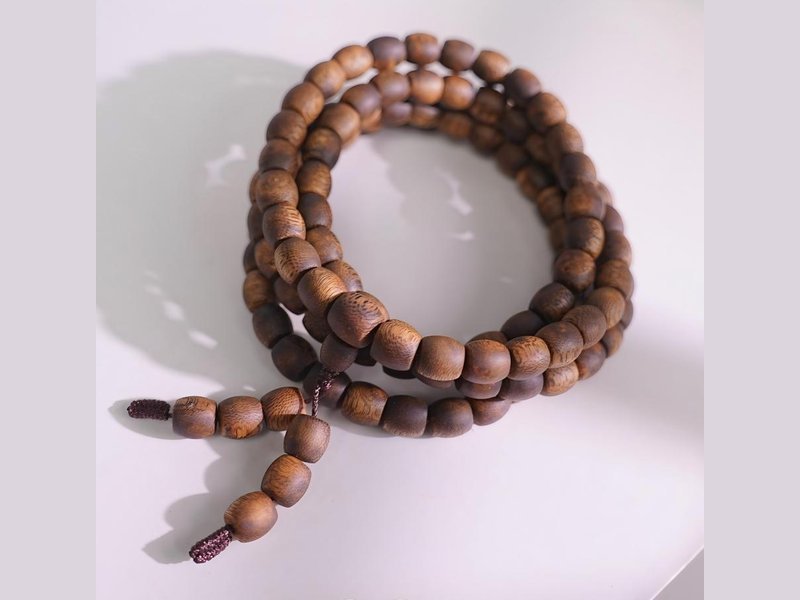 Multi-wrap agarwood drum bead bracelet showing natural variation in resin colour from bead to bead